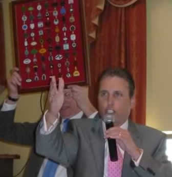 Comedian, Russ Williams, auctioning the framed display of racecource badges